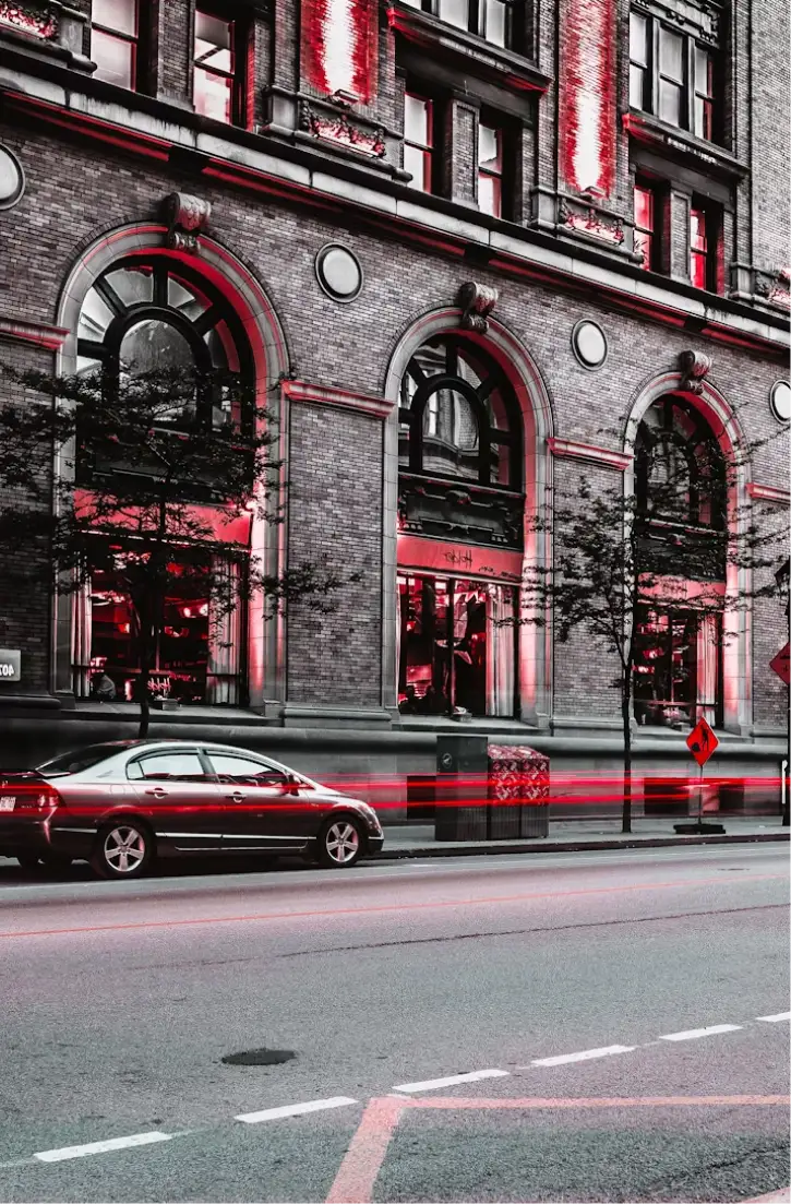 Photo of a car parked in front of a New York City mixed-use building